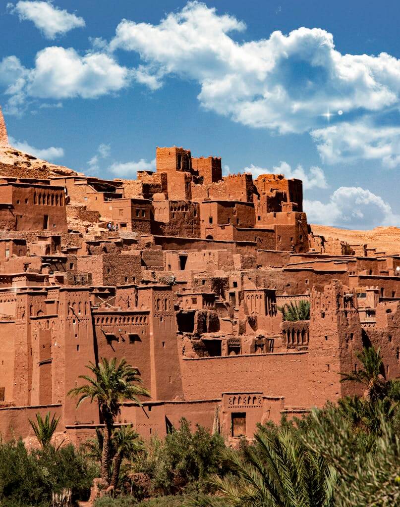 Aerial view of ancient Ait Benhaddou clay structures with clear skies and clouds.