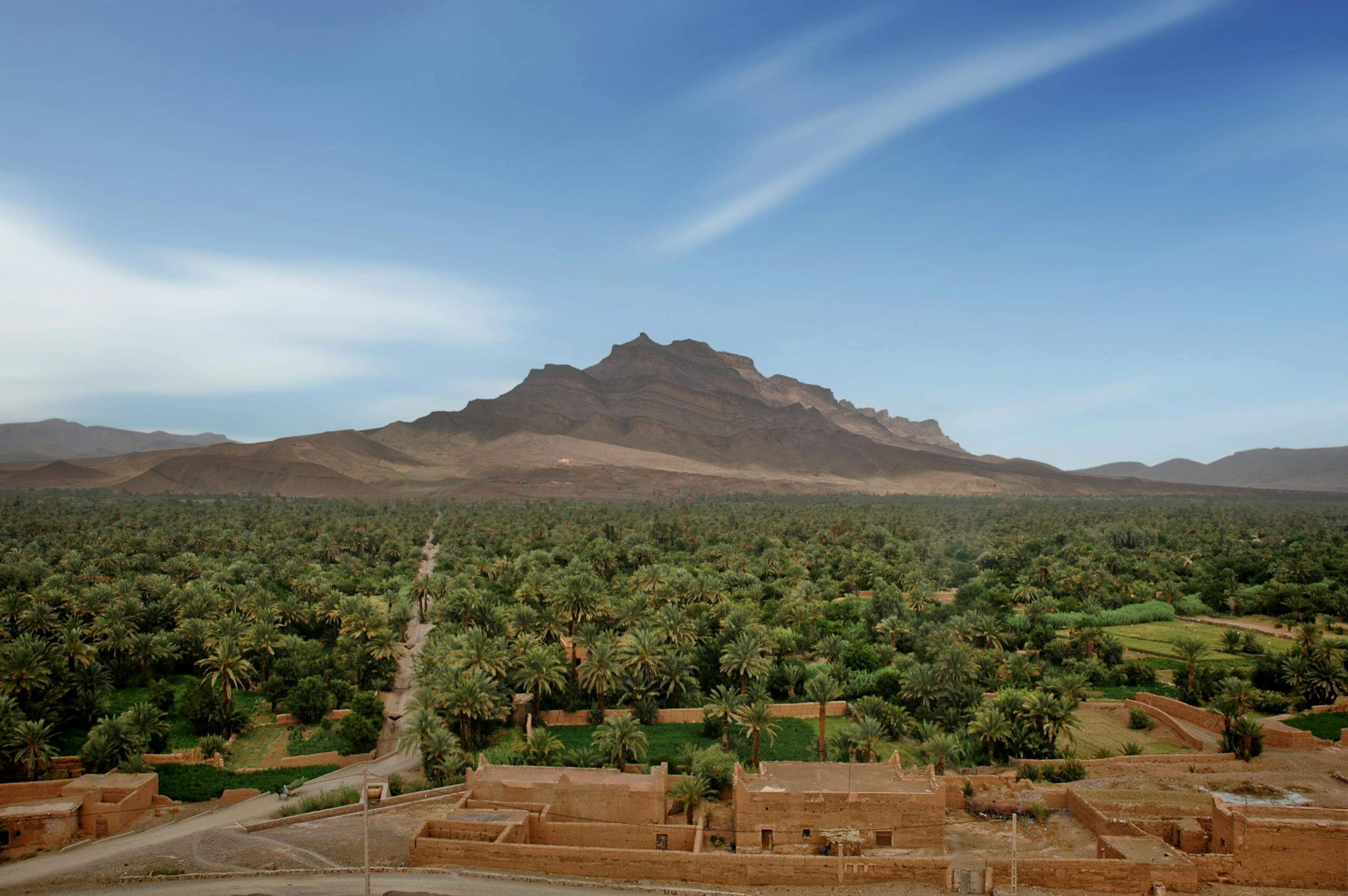Breathtaking landscape of the lush Drâa Valley with mountains and greenery in Morocco.