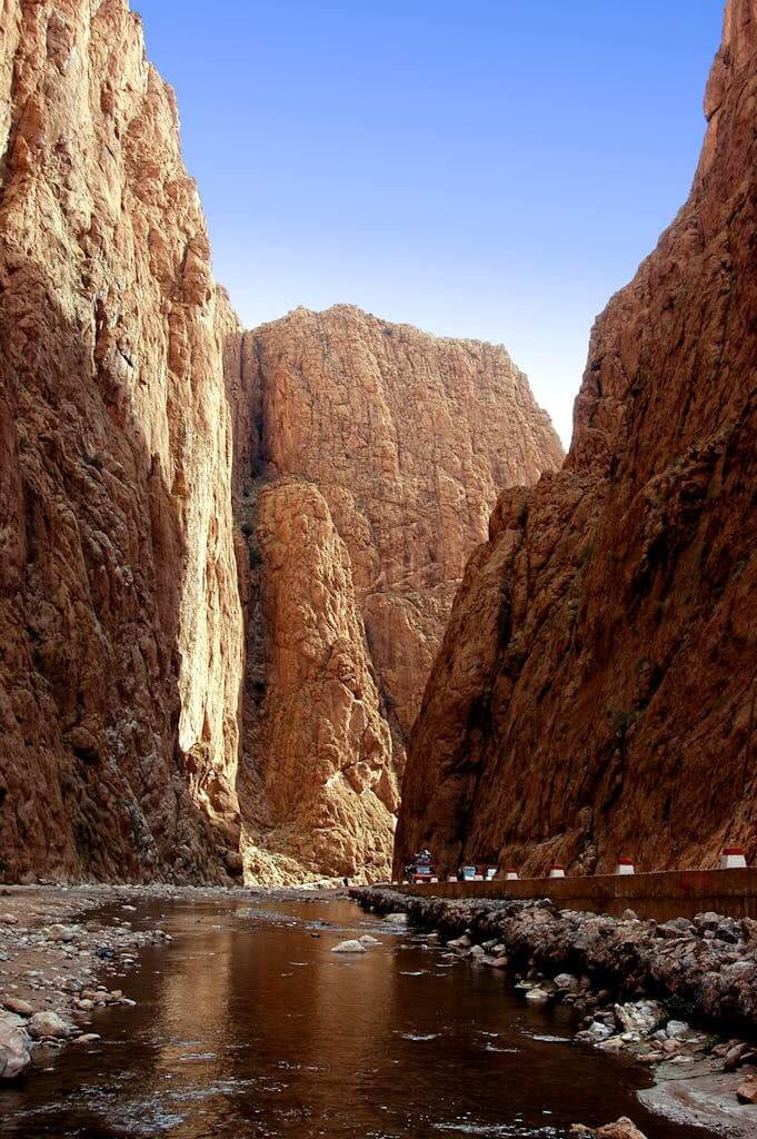 Captivating view of Todra Gorge's towering cliffs and tranquil stream in Tinghir, Morocco.