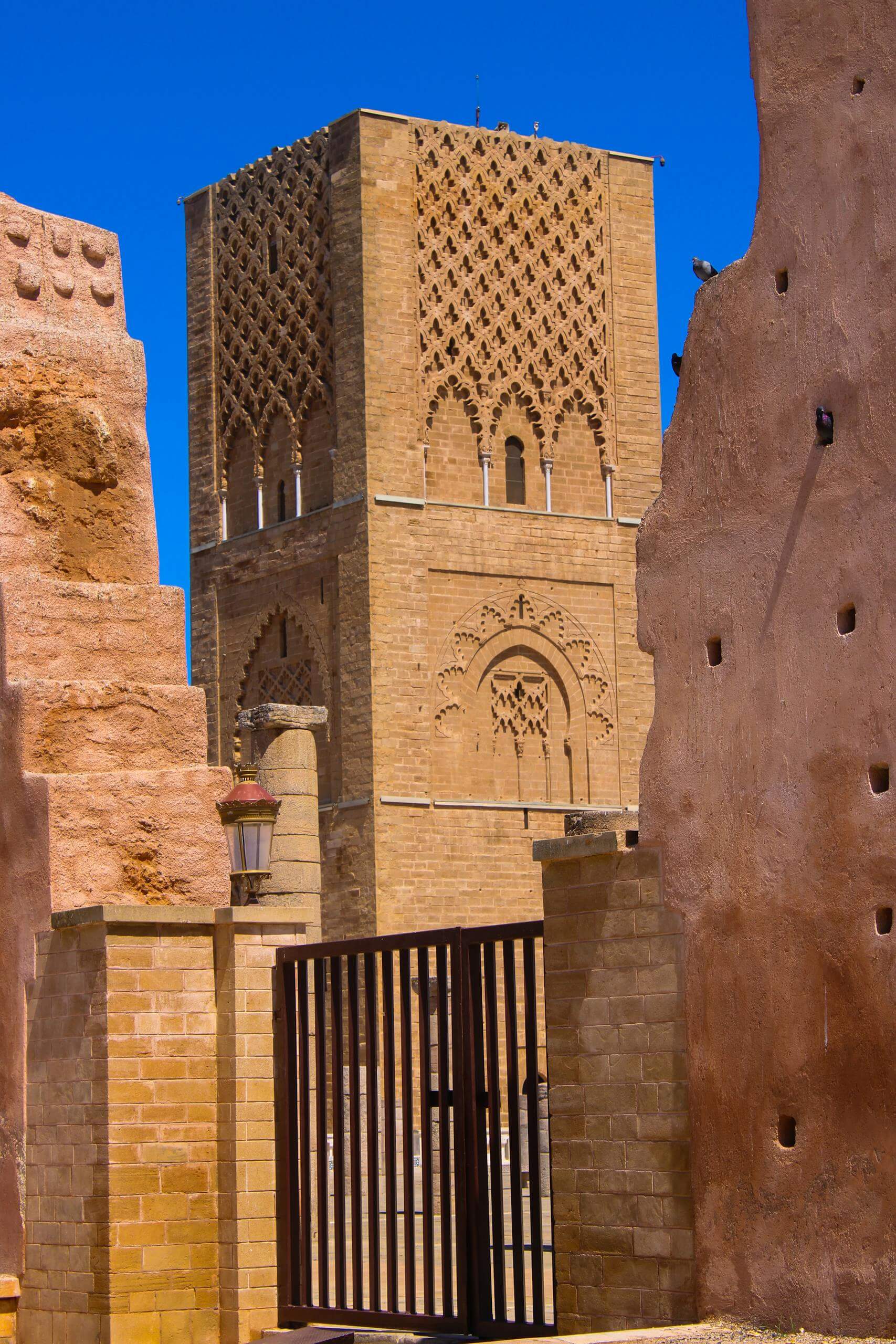 View of Hassan Tower in Rabat, Morocco, showcasing iconic Islamic architecture under a bright blue sky.